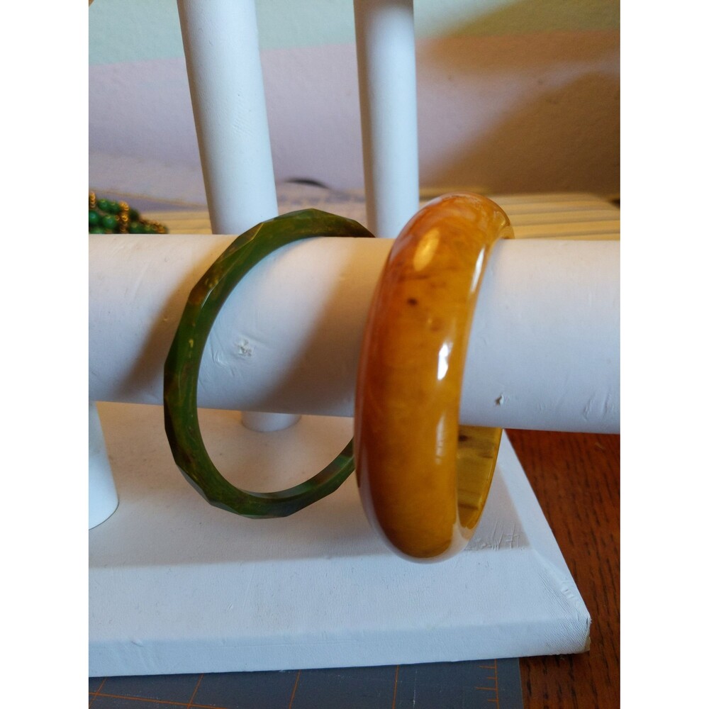 Lot of two Bakelite bangle bracelets. Green and brown carved marbled. Gold and b
